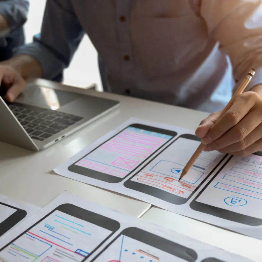 App-Konzept mit UX-Wireframes, Laptop und gemeinsamer Planung als Symbol für ganzheitliche App-Entwicklung in Graz