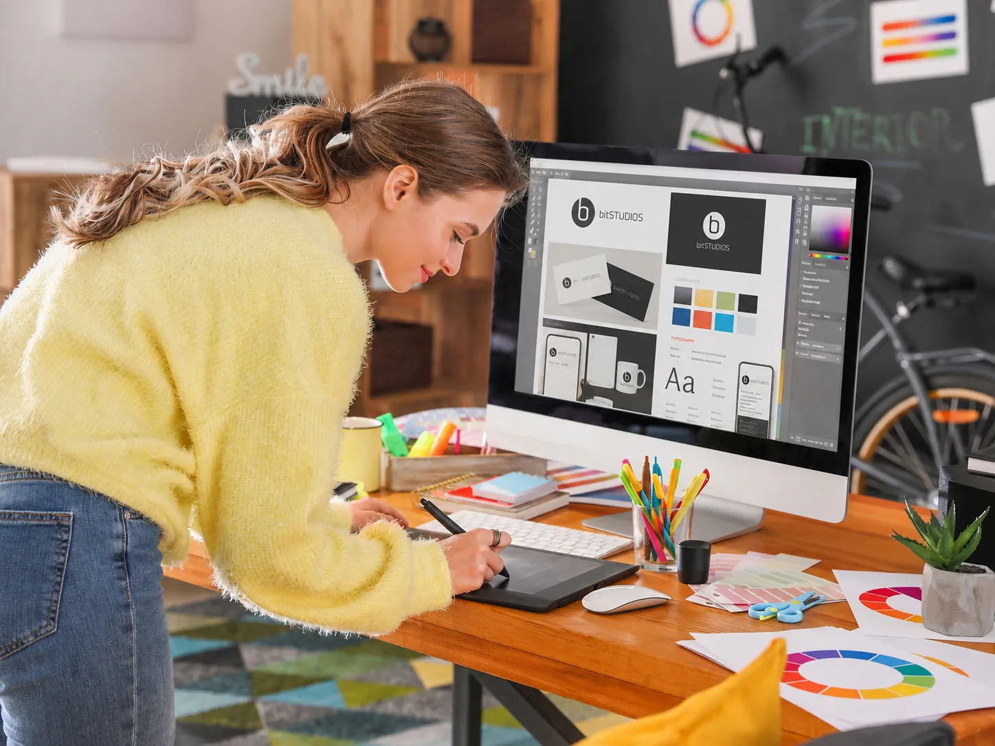 Grafikdesignerin arbeitet an einem bitSTUDIOS Corporate-Design-Entwurf mit Logo, Farbsystem, Typografie und Markenanwendungen